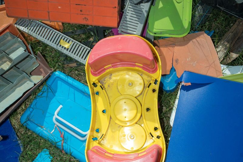 pexels-photo-30210765-30210765-1 Top view of colorful plastic toys and items among various recycling materials.